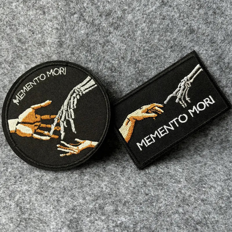 Memento Mori patch shown next to round variant for scale
