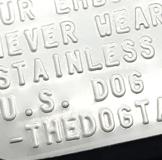 Close-up of embossed lettering on dog tag surface